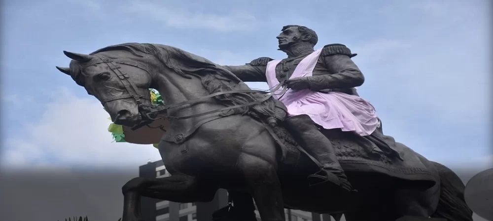 En franco irrespeto, María Galindo y Mujeres Creando ponen un mandil al monumento a Antonio José de Sucre
